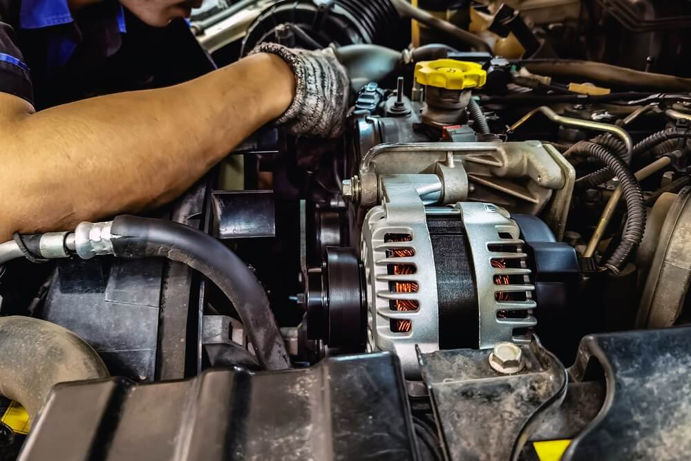 Close-up of an alternator under the hood of a pickup truck